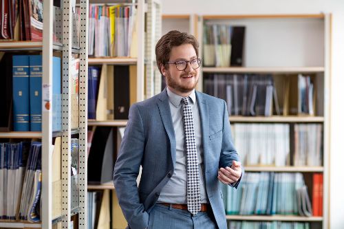 Rechtsreferendar Marius Möhrle zwischen Bücherregalen