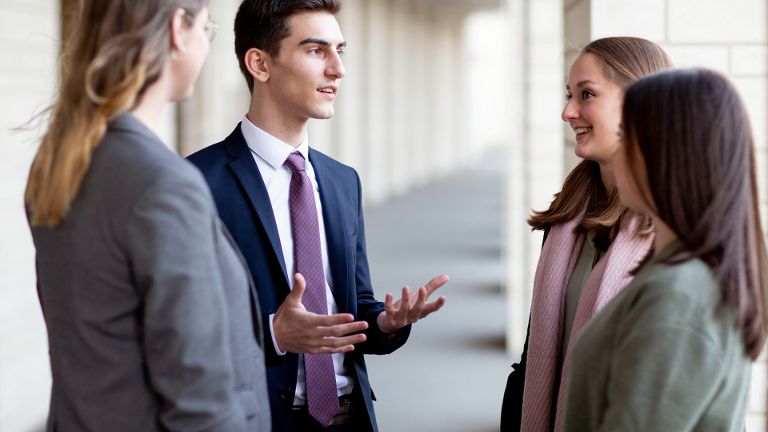 Gruppe von Studierenden und Absolvent:innen im Gespräch