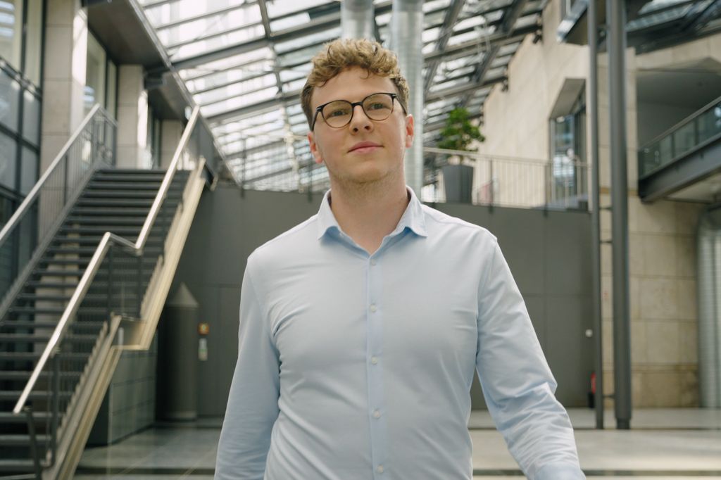 Ein junger Mann läuft in einem großen, luftigen Raum.