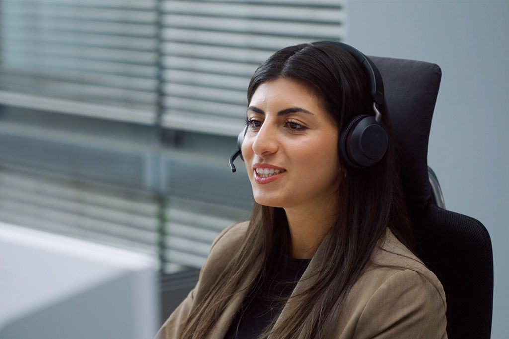 Junge Frau telefoniert mit Headset in einem Büro.