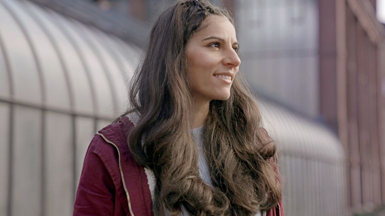 Eine lächelnde junge Frau, die in die Ferne schaut