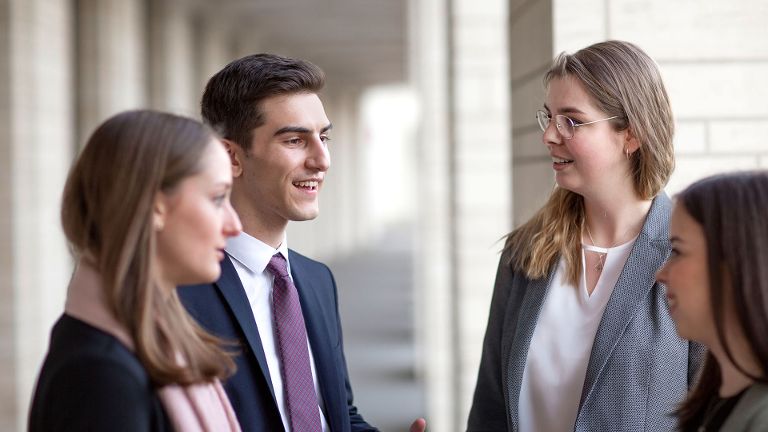 Gruppe von Studierenden und Absolvent:innen im Gespräch