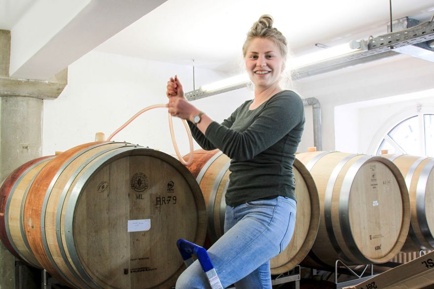 Azubi Jasmin Andelfinger zwischen Weinfässern