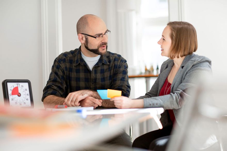Scrum Master Jonathan Rothenberg spricht mit Kollegin.