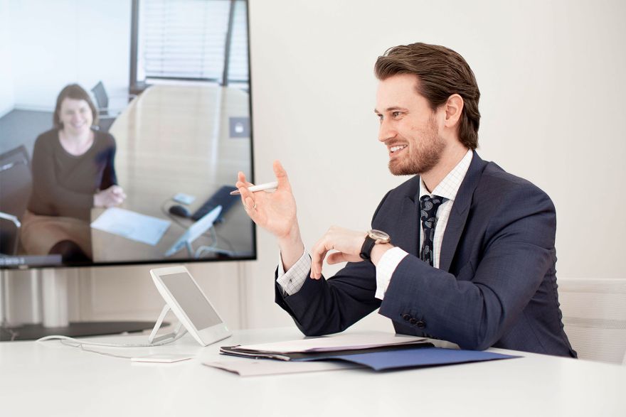 Manuel Kull an einem Besprechungstisch in einer Videokonferenz