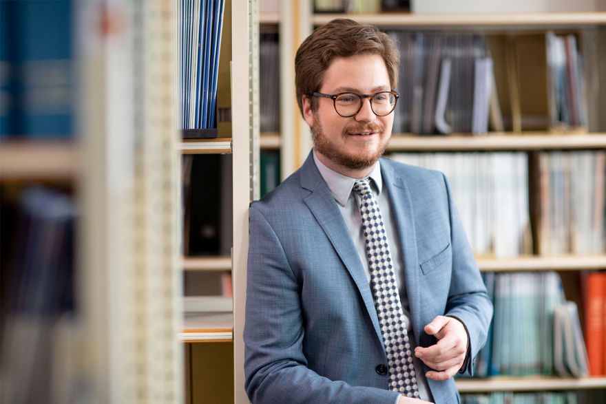 Rechtsreferendar Marius Möhrle zwischen Bücherregalen