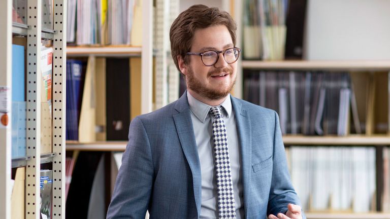 Rechtsreferendar Marius Möhrle zwischen Bücherregalen
