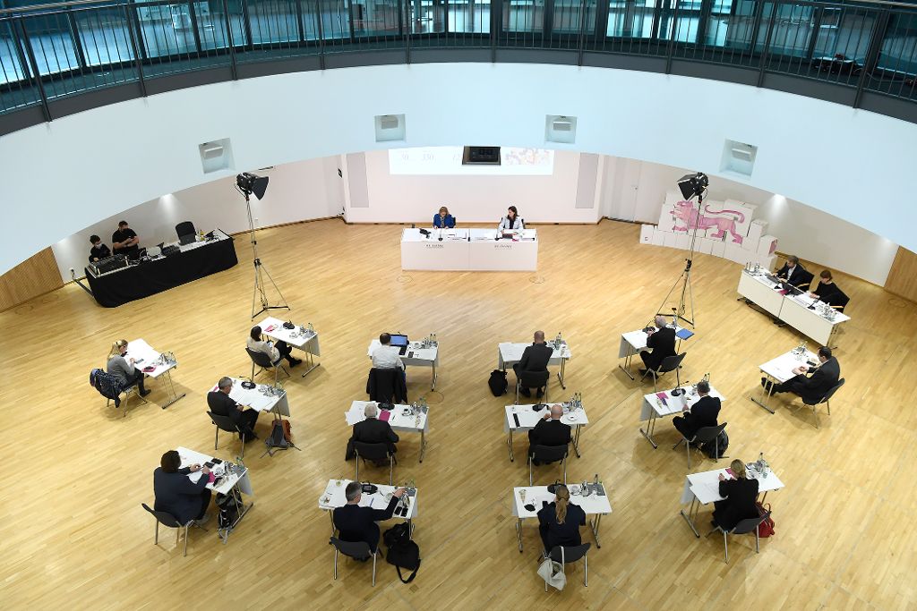 Medienschaffende sitzen parlamentarisch vor einem Podium.