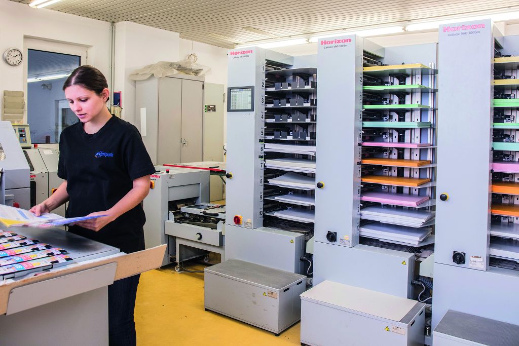 Eine Mitarbeiterin arbeitet in der Printpark Widmann GmbH Druckerei.