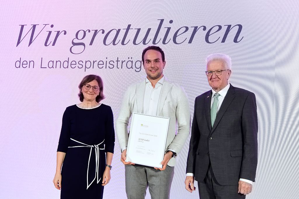 Ministerpräsident Winfried Kretschmann und Vorstandsvorsitzende der L-Bank Edith Weymayr überreichen Urkunde an AITAD.
