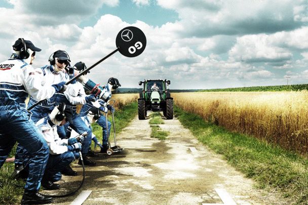 Eine Fotomontage, bei der auf der linken Seite ein Formel-1-Team kurz vor einem Boxenstopp abgebildet ist, mittig fährt ein Trecker anstelle eines Formel-1-Wagens