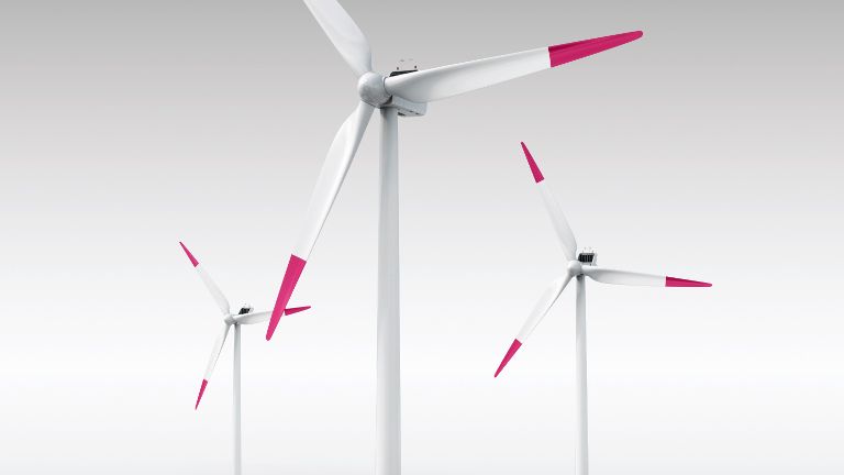Drei weiße Windräder miir rot-weißen Rotoren vor einem grauweißen Hintergrund